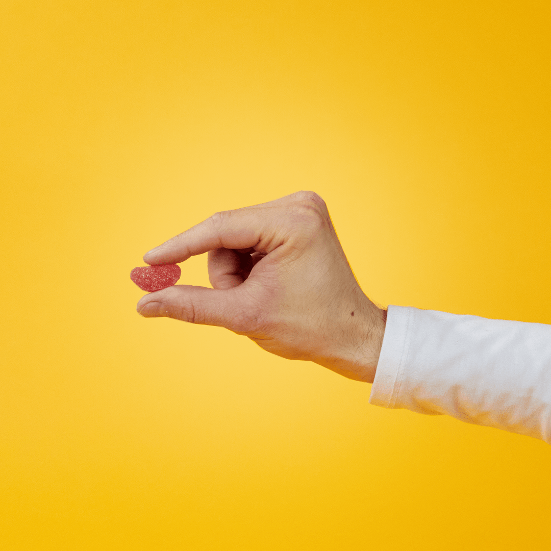 A man holds an Airborne Immune Essential gummy
